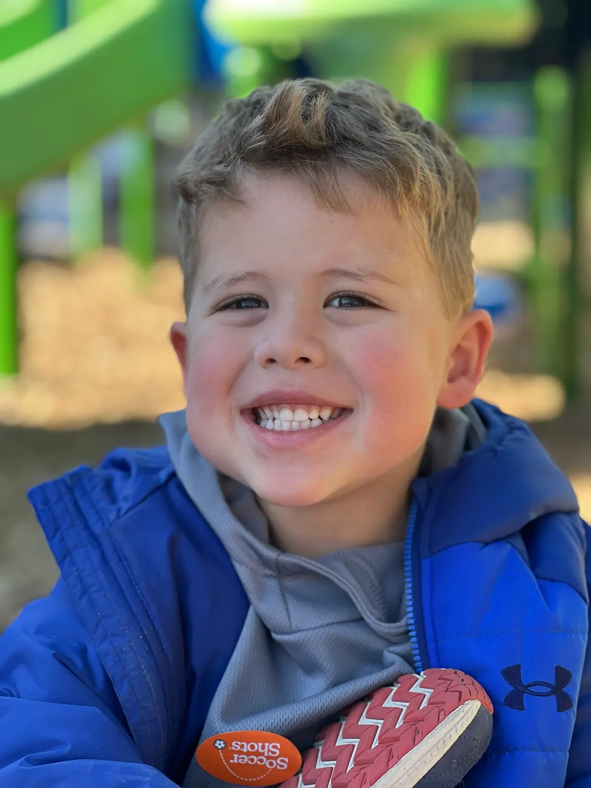 A smiling First Presbyterian Preschool student on the playground
